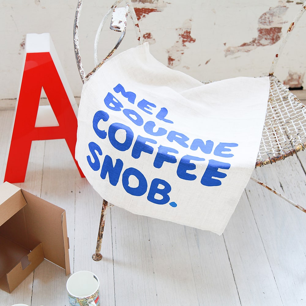 Make Me Iconic Coffee Snob Tea Towel celebrating Melbourne’s coffee culture, as featured by Kylie Minogue on Instagram, perfect for caffeine lovers and city pride.