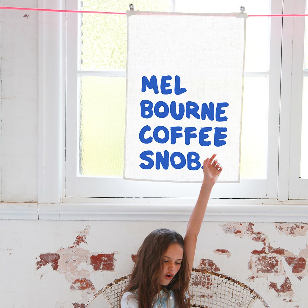 Make Me Iconic Coffee Snob Tea Towel celebrating Melbourne’s coffee culture, as featured by Kylie Minogue on Instagram, perfect for caffeine lovers and city pride.