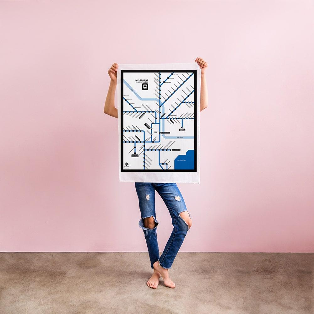 Make Me Iconic Melbourne Train Network Tea Towel featuring an illustrated map of Melbourne’s railway system, an Australian souvenir celebrating iconic public transport.
