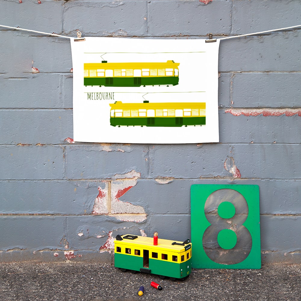 Make Me Iconic Melbourne Tram Tea Towel featuring the classic green and gold W-Class tram with vintage destination banner, an iconic Australian gift and kitchen textile.