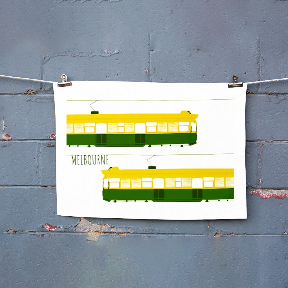 Make Me Iconic Melbourne Tram Tea Towel featuring the classic green and gold W-Class tram with vintage destination banner, an iconic Australian gift and kitchen textile.
