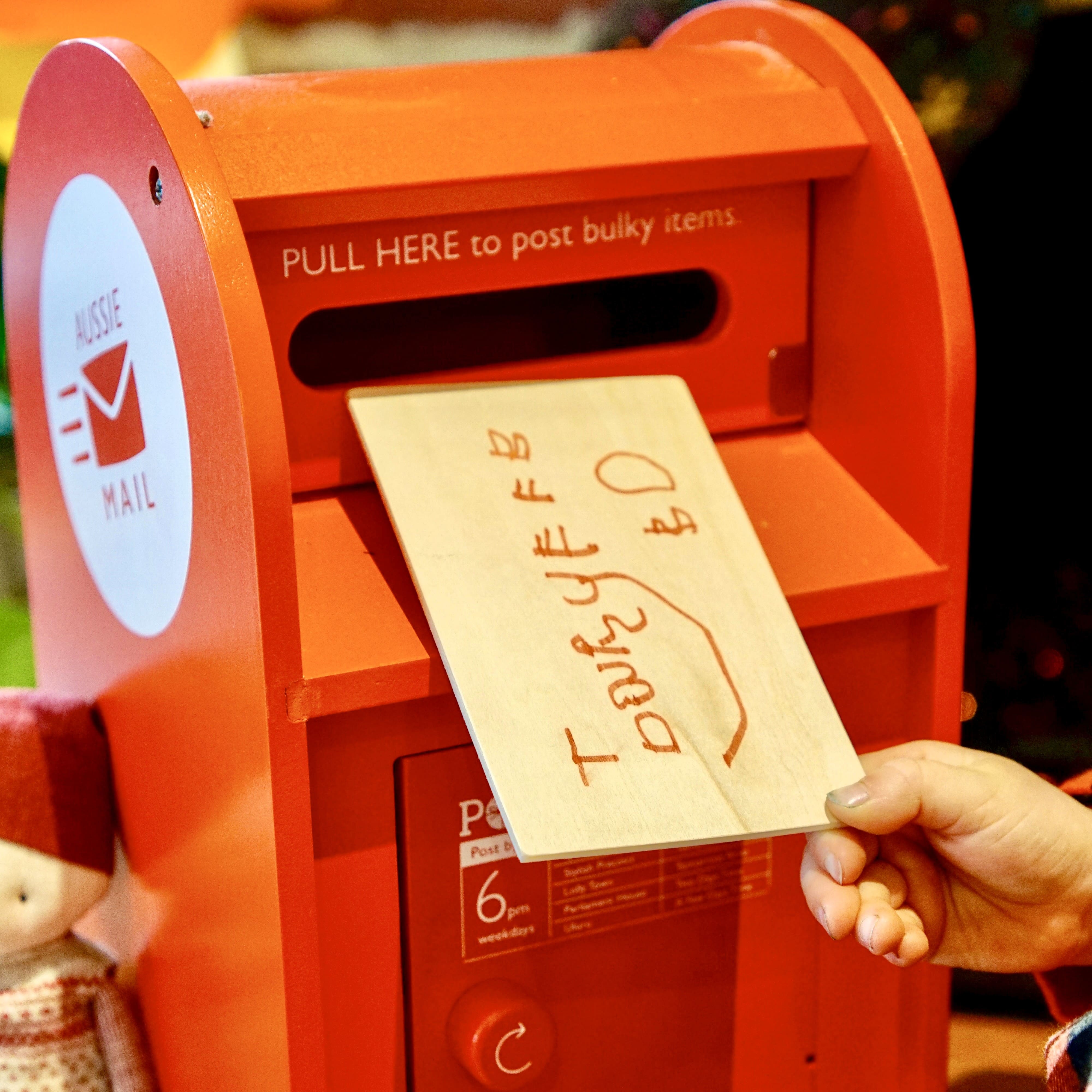 Wooden Australian post box toy with working mail slot, 6 wooden letters, and 6 Velcro stamps perfect for imaginative pretend play and storytelling.