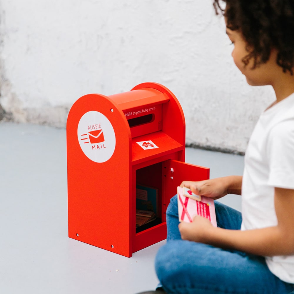 Wooden Australian post box toy with working mail slot, 6 wooden letters, and 6 Velcro stamps perfect for imaginative pretend play and storytelling.