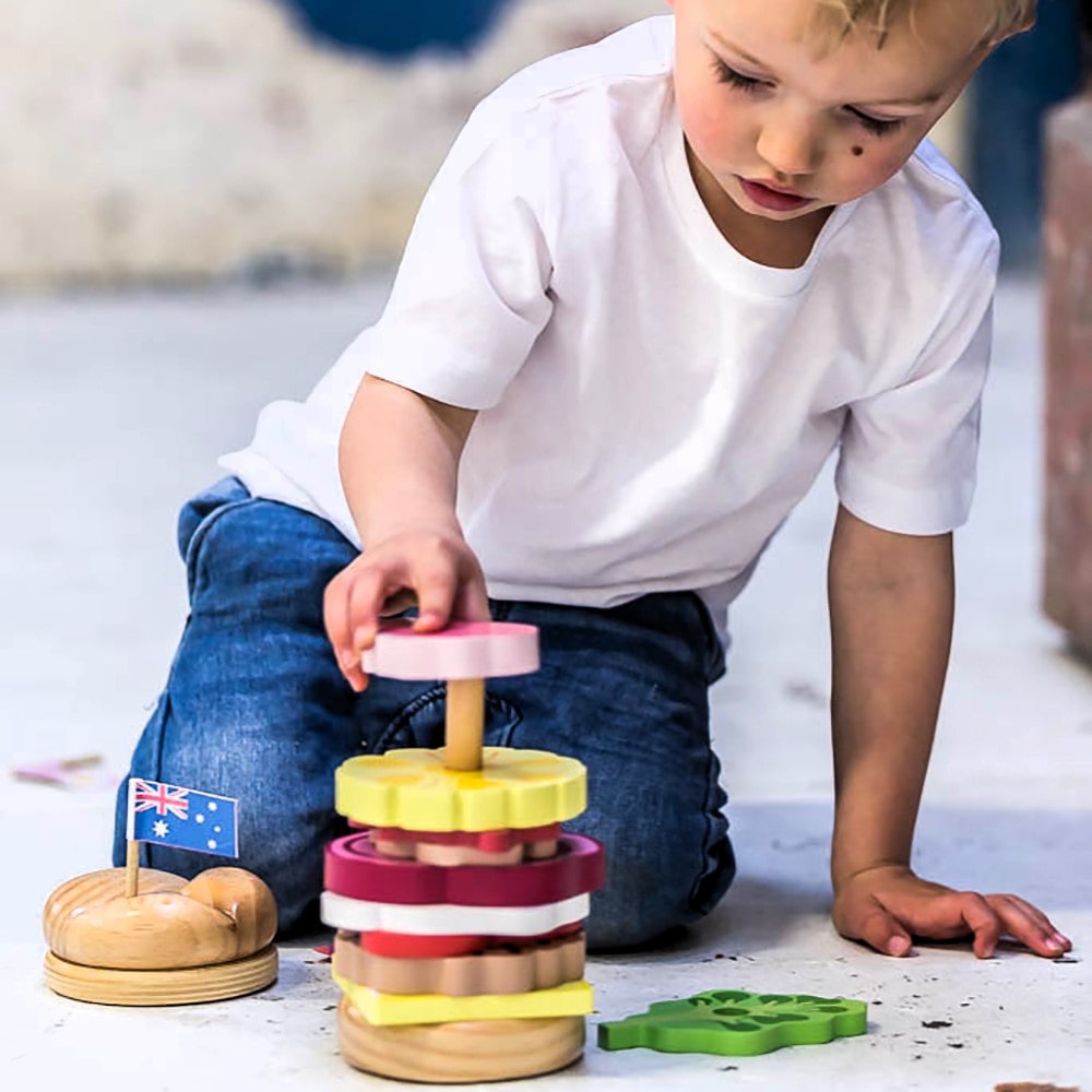 Wooden Aussie stacking burger toy for kids with colourful layers, mini flags, and chunky pieces—perfect for imaginative food play and motor skill development.