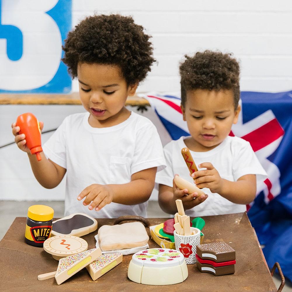 Make Me Iconic Australian wooden toy food set, 38-piece pretend play set featuring Vegemite, Fairy Bread, Pavlova, Lamington, meat pie, snag in bread, and hot Chips with sauce for imaginative kitchen play.