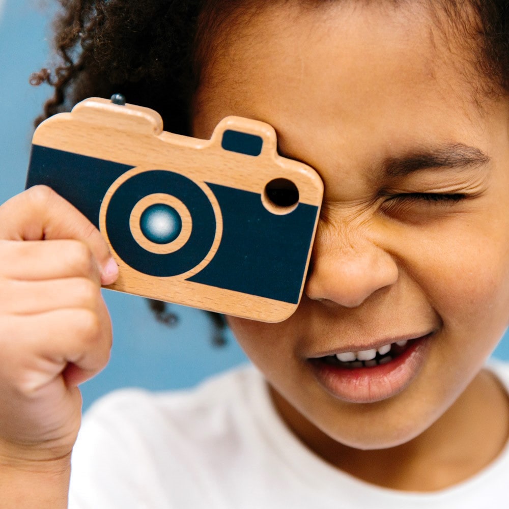 Wooden toy camera for kids with real viewfinder and pressable button, designed for imaginative pretend play and creative role-play photography fun.
