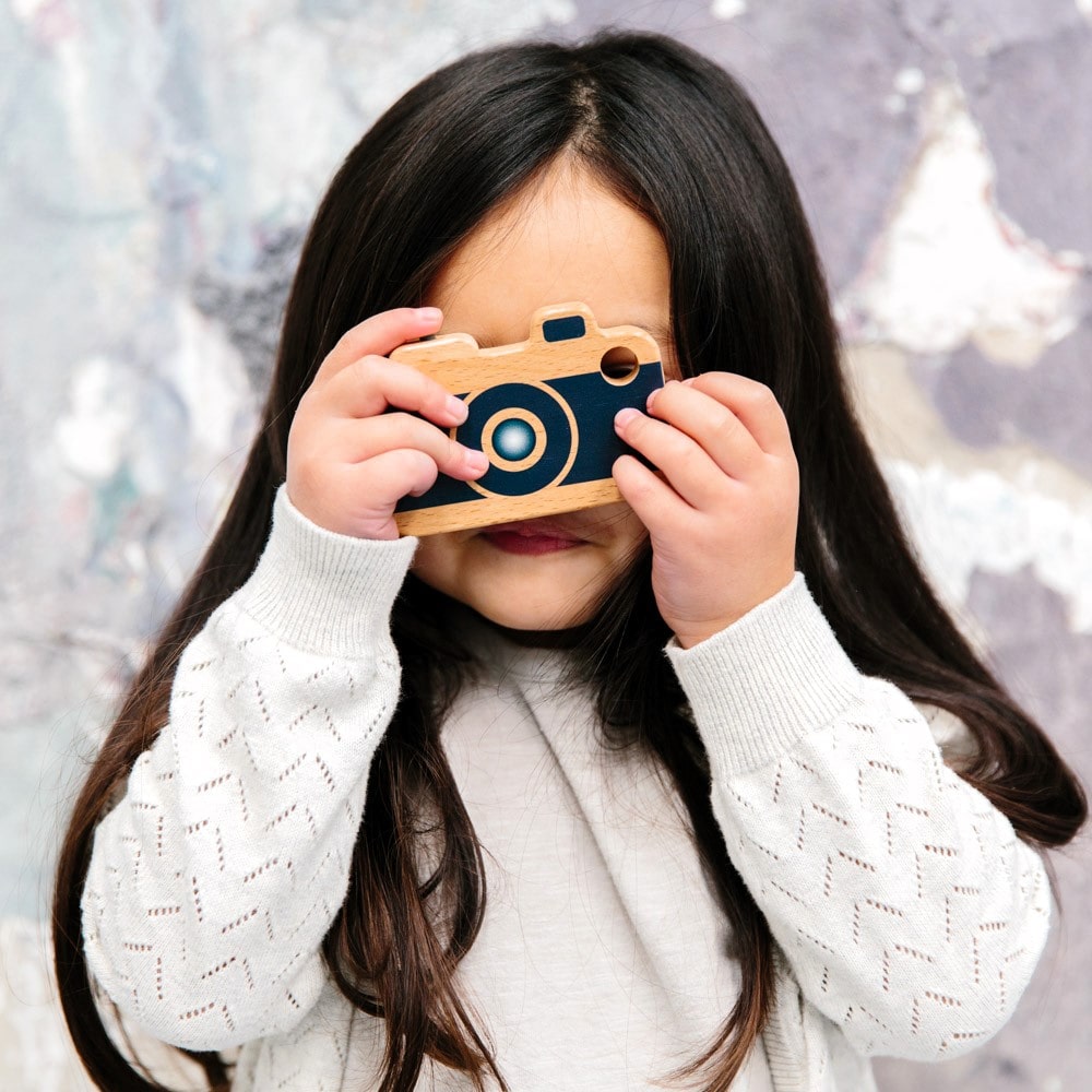 Wooden toy camera for kids with real viewfinder and pressable button, designed for imaginative pretend play and creative role-play photography fun.