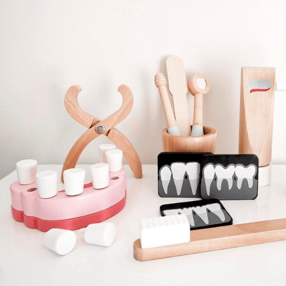 Wooden toy dentist kit with model mouth, removable teeth, dental tools, and carry box for imaginative pretend play