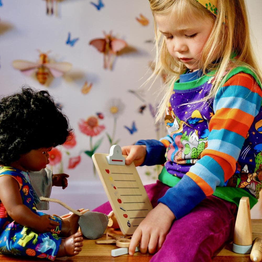 Make Me Iconic wooden Doctor’s Kit for kids, gender-neutral pretend play set with real wooden tools including stethoscope, syringe, and thermometer. Encourages imaginative play, empathy, and role-playing for young doctors and nurses.