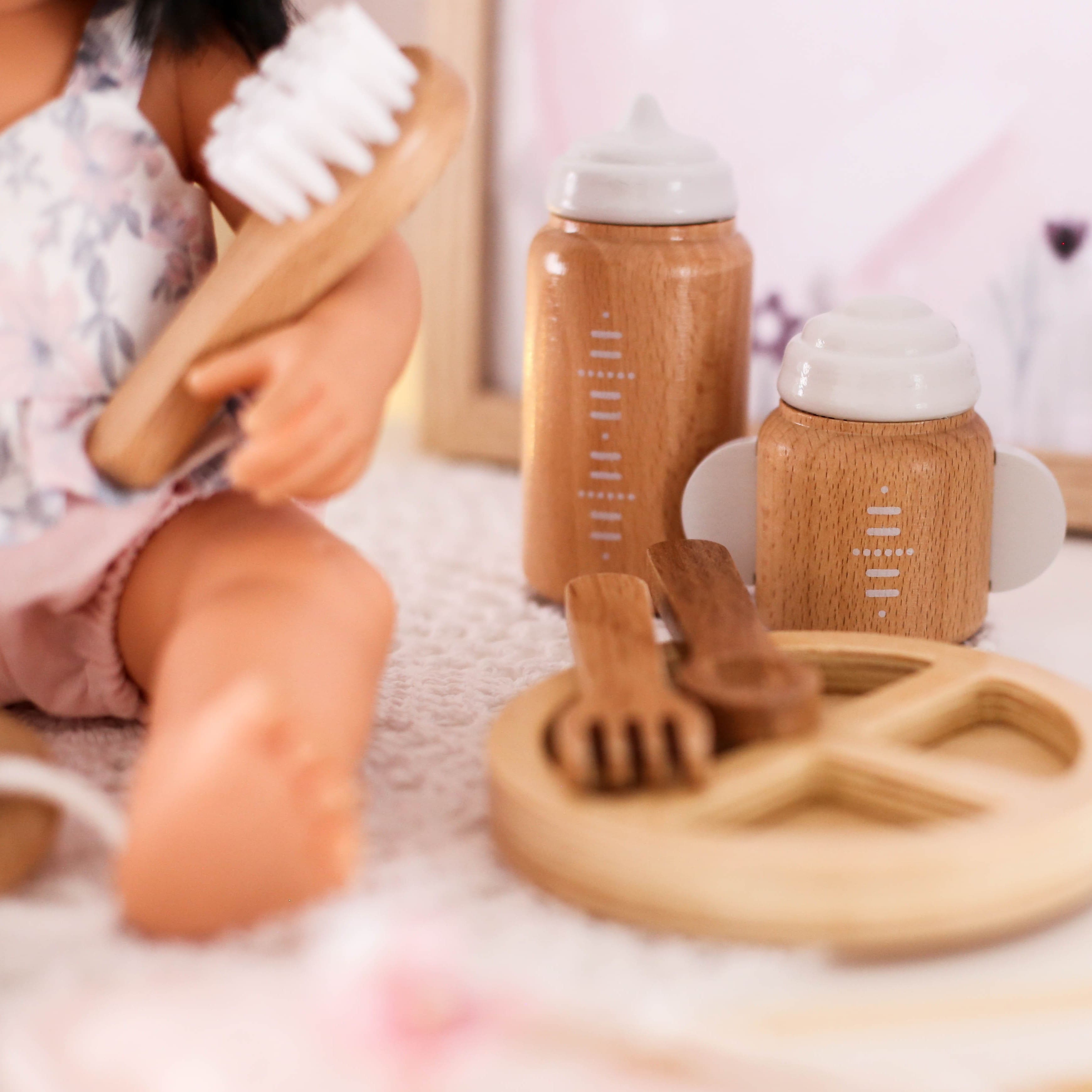 Make Me Iconic 11-piece wooden doll accessory kit with bottles, sippy cup, bowl, fork, spoon, brush with real bristles, comb, teether, and clip-on pacifier – perfect for pretend play.