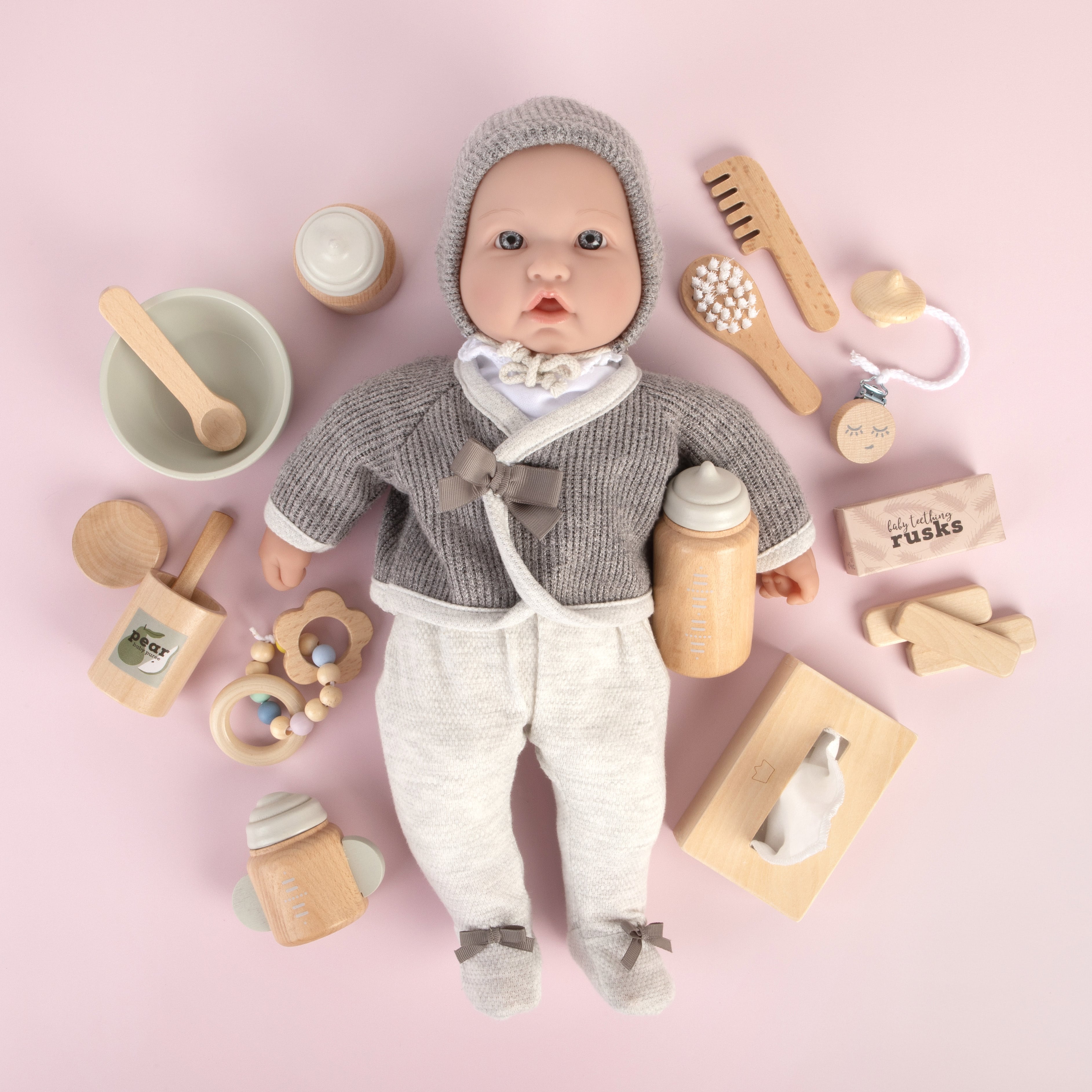Make Me Iconic 11-piece wooden doll accessory kit with bottles, sippy cup, bowl, fork, spoon, brush with real bristles, comb, teether, and clip-on pacifier – perfect for pretend play.