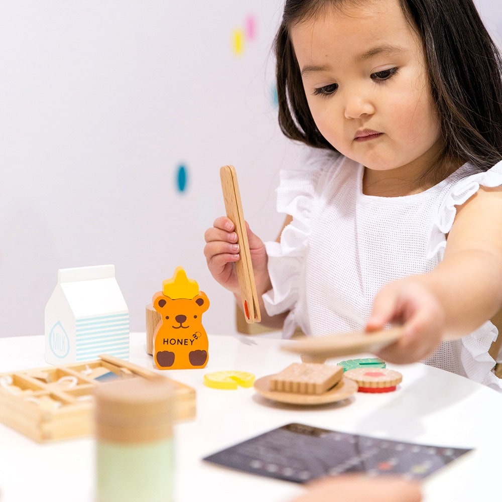 Make Me Iconic 27-piece wooden toy Tea Set Extension Set with tea cups, tea bags, tongs, cookies, and accessories. Ideal for pretend play and perfectly matched with our wooden toy Tea Set.