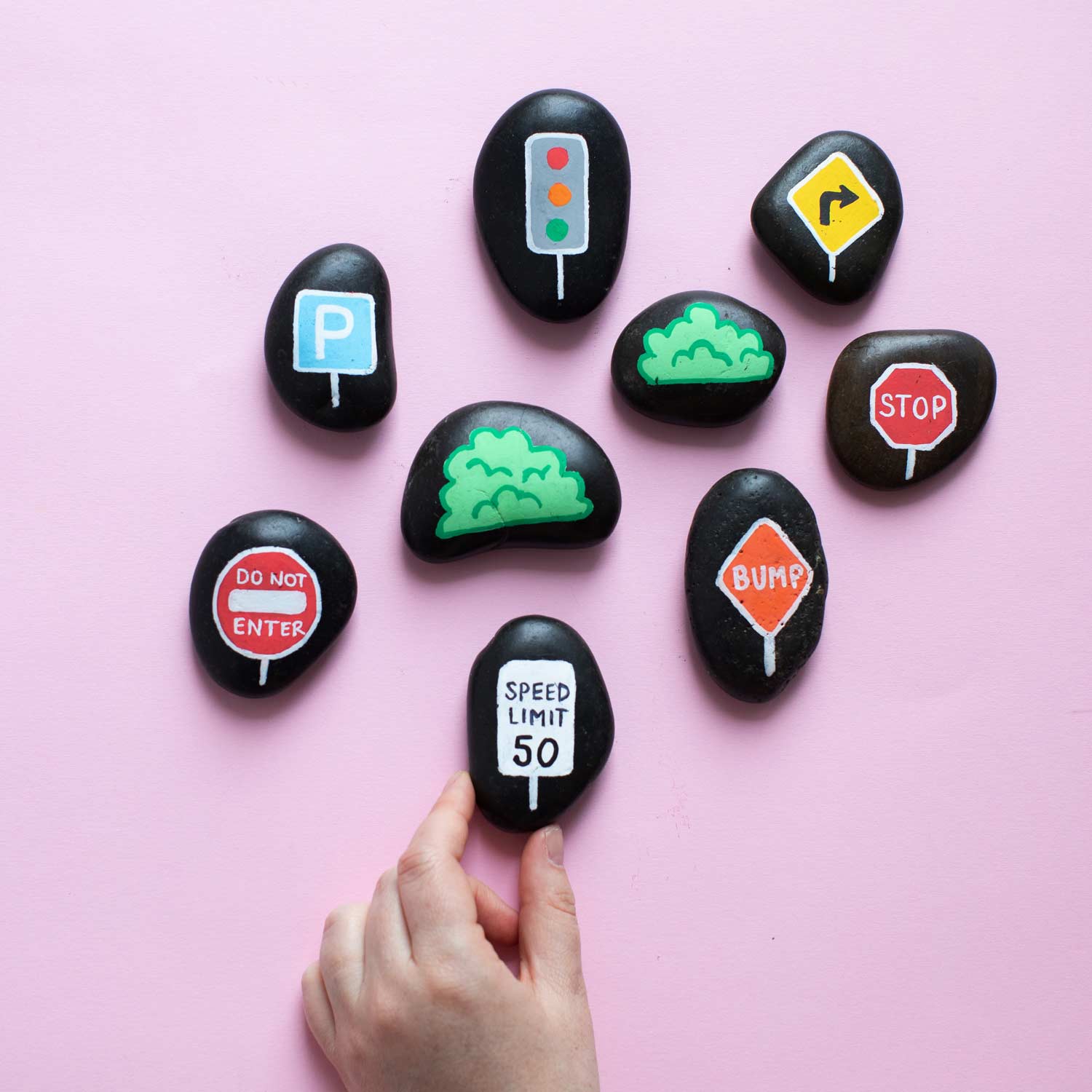 Painted rocks craft for kids using POSCA paint pens and smooth stones – fun DIY nature activity to encourage creativity and imaginative play.