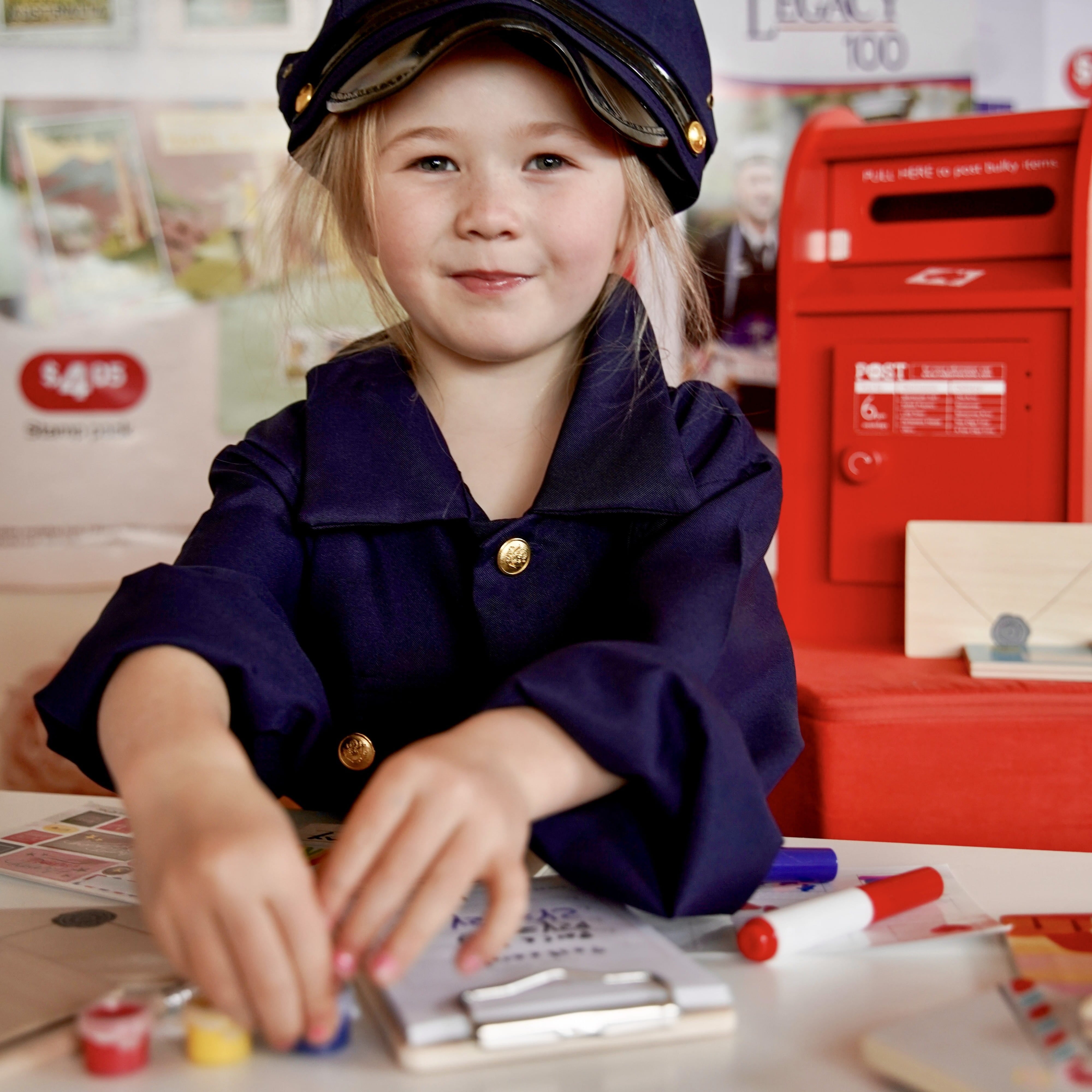 Child playing with a wooden Iconic Post Box toy, posting letters during imaginative pretend play at home in Australia