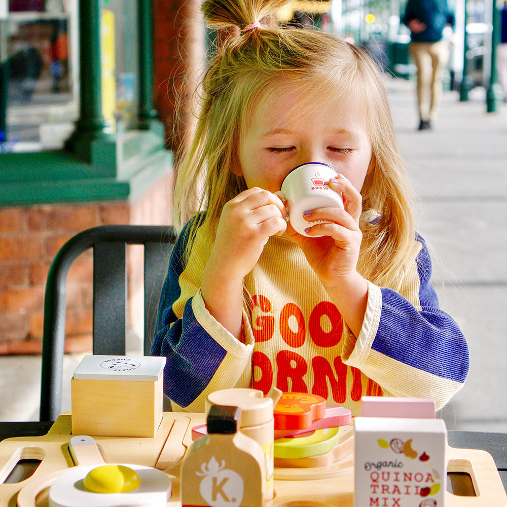 Child playing with wooden healthy brekkie set including avocado toast and café accessories for imaginative pretend play