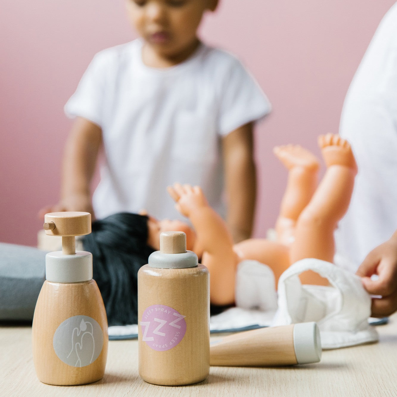 Wooden doll nurturing kit with potty training accessories and soft fabric items for imaginative pretend play in toddlers