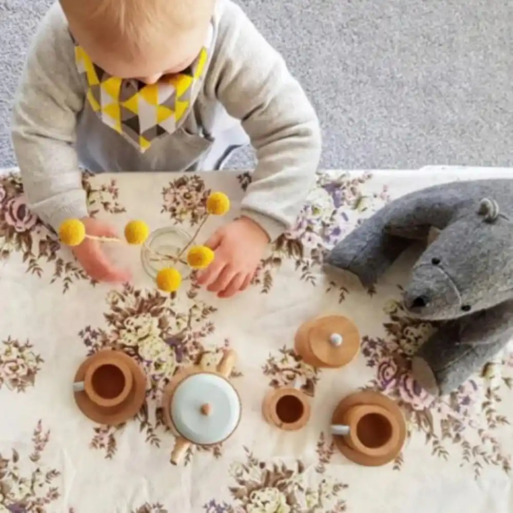 Children playing with a wooden toy tea set during a pretend play tea party indoors. Why Water and Wooden Toys Don’t Mix. Make Me Iconic tea set is perfect for imaginative pretend play.
