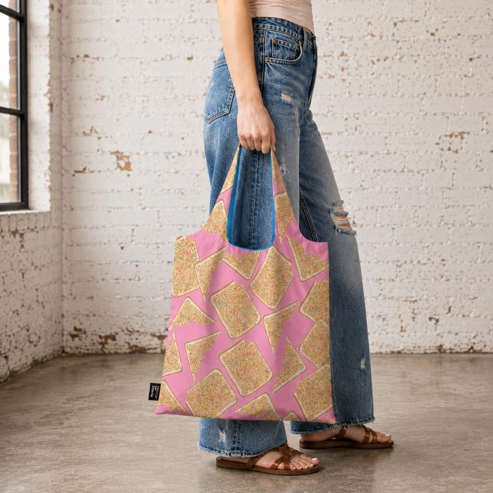 A Make Me Iconic reusable foldable shopping bag featuring a playful Fairy Bread design with slices of white bread covered in colourful hundreds and thousands on a pink background. Made from 100% recycled fabric, this lightweight, eco-friendly shopping bag folds neatly into its own matching pouch, making it perfect for everyday shopping, travel, or keeping in your handbag. It celebrates one of Australia's most nostalgic party treats in a fun and practical design.