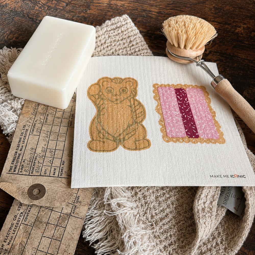Iconic Bickies Swedish Dish Cloth featuring classic Australian biscuits including a Teddy Bear, Scotch Finger and Iced VoVo. Made from natural, eco-friendly fibres, this reusable dish cloth is super absorbent, durable and perfect for everyday kitchen cleaning. A nostalgic Aussie kitchen essential that pairs beautifully with Make Me Iconic tea towels and makes a thoughtful Australian gift or souvenir.