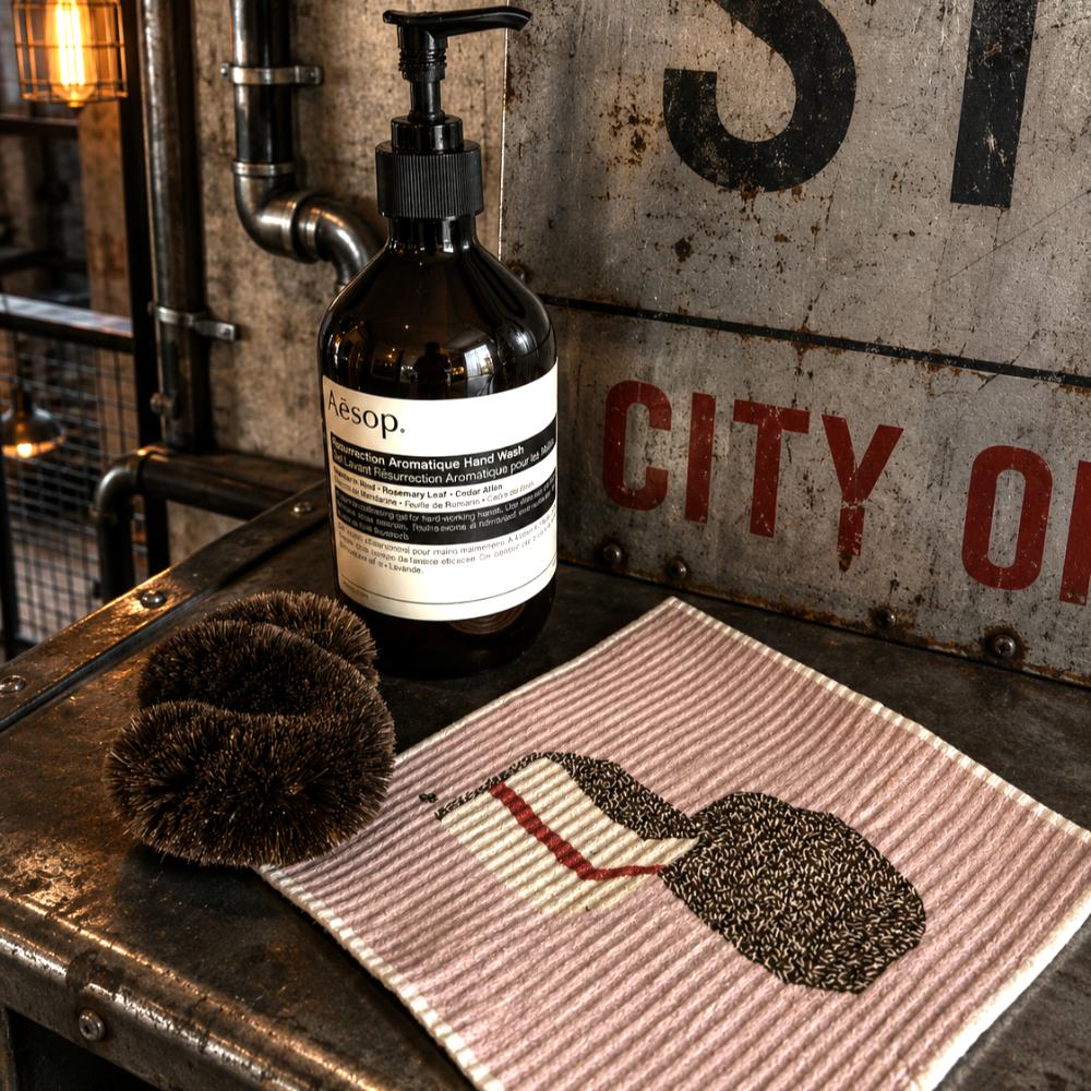 A Make Me Iconic reusable Swedish dishcloth featuring illustrations of a classic Australian lamington and a Strawberry Big M milk carton. The eco-friendly sponge celebrates two iconic Aussie treats in a colourful nostalgic design, making it a fun and practical kitchen cleaning cloth for everyday use.