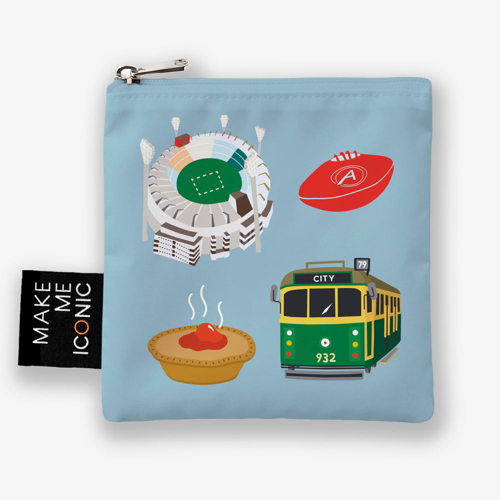 A Make Me Iconic reusable foldable shopping bag featuring iconic Melbourne landmarks and symbols including a W-Class tram, MCG, Flinders Street Station, coffee, meat pie, rain, and AFL football. Made from 100% recycled fabric, this lightweight eco-friendly tote folds into a compact pouch for shopping, travel, and everyday use.