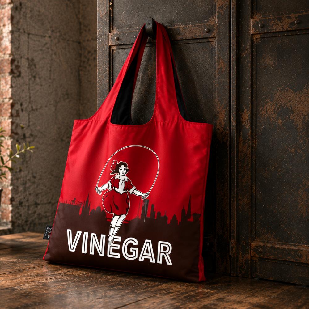 A Make Me Iconic reusable foldable shopping bag featuring Melbourne's iconic Skipping Girl neon sign. Made from 100% recycled fabric, this lightweight eco-friendly tote folds into a compact pouch and holds up to 20kg for everyday shopping