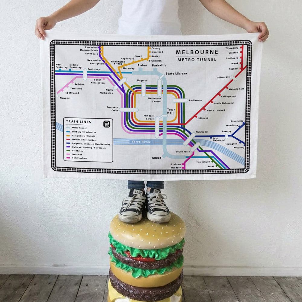 Iconic Melbourne Metro Tunnel Tea Towel featuring an illustrated map of Melbourne's Metro Tunnel project, including the five new underground stations at Arden, Parkville, State Library, Town Hall and Anzac,
