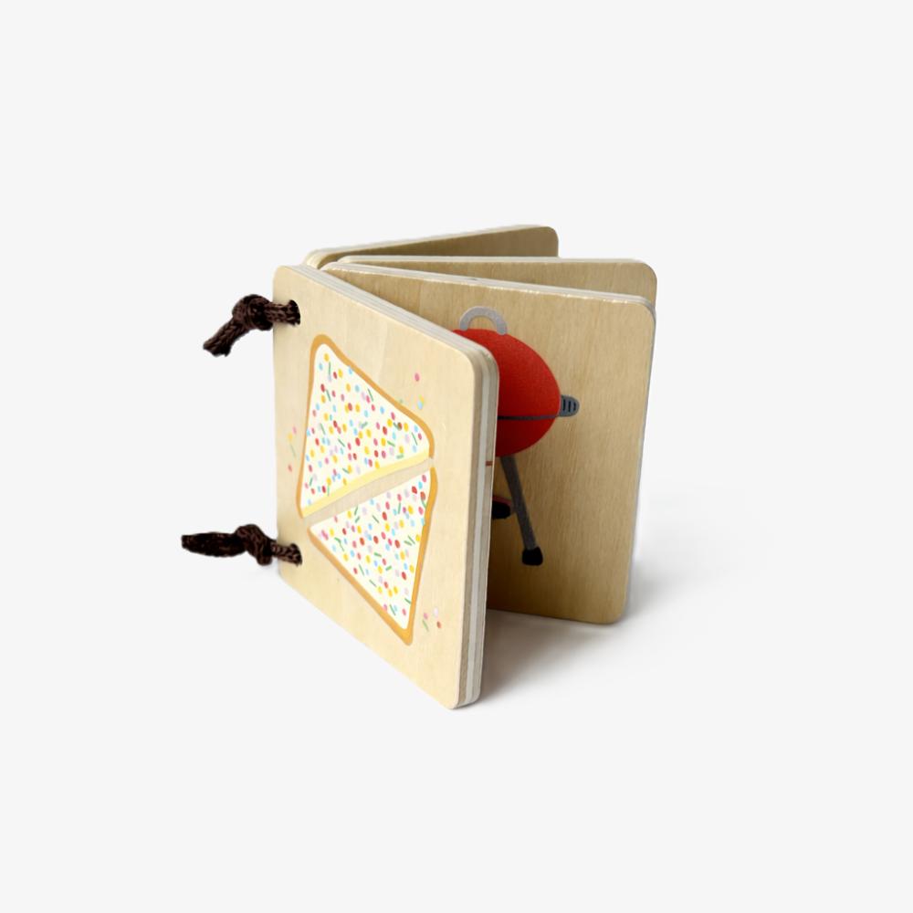 Make Me Iconic Iconic Australian Favourites mini wooden book for toddlers, featuring Aussie icons including fairy bread, Ugg boots, surfboards and beach days for early learning, word recognition and screen-free play.