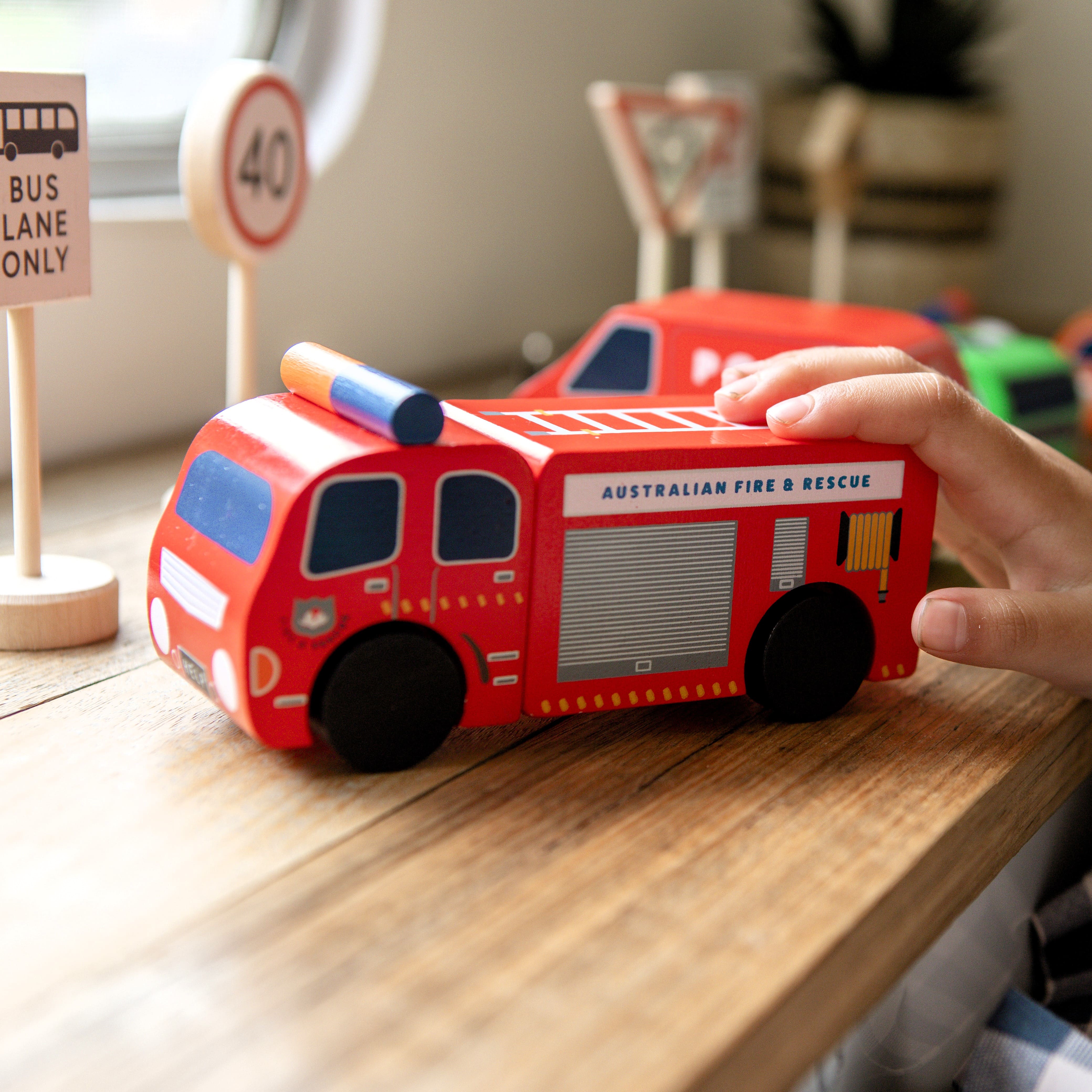Aussie wooden toy vehicle set featuring Sandman Panel Van, retro-orange ute, fire truck, and postie bike for imaginative play