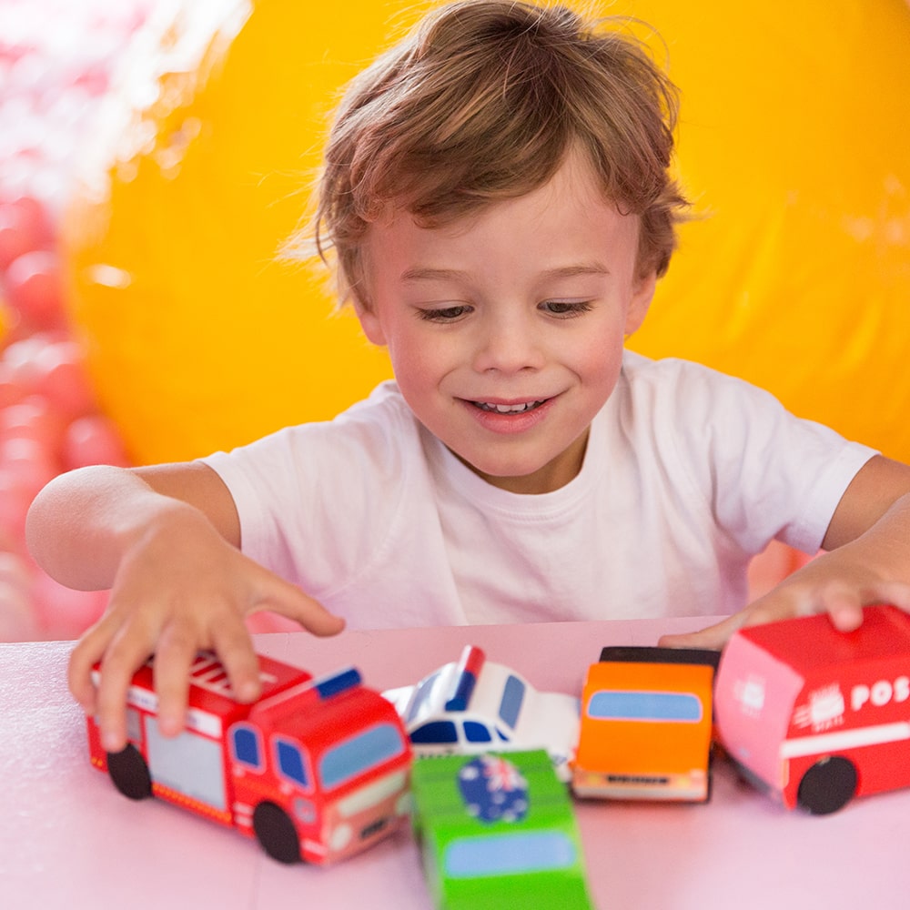 Aussie wooden toy vehicle set featuring Sandman Panel Van, retro-orange ute, fire truck, and postie bike for imaginative play