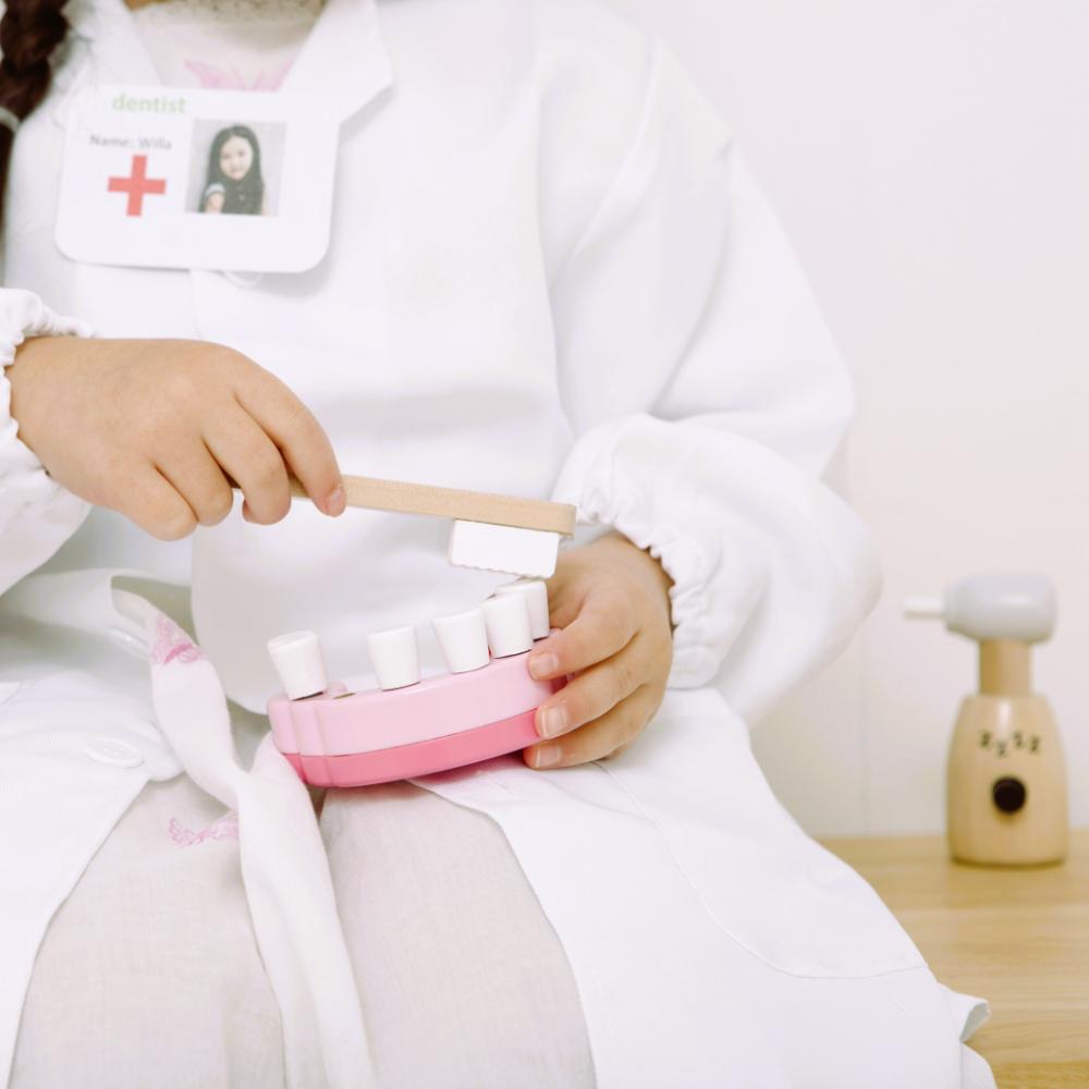 Make Me Iconic wooden toy dentist kit with model mouth, removable teeth, dental tools, and carry box for imaginative pretend play