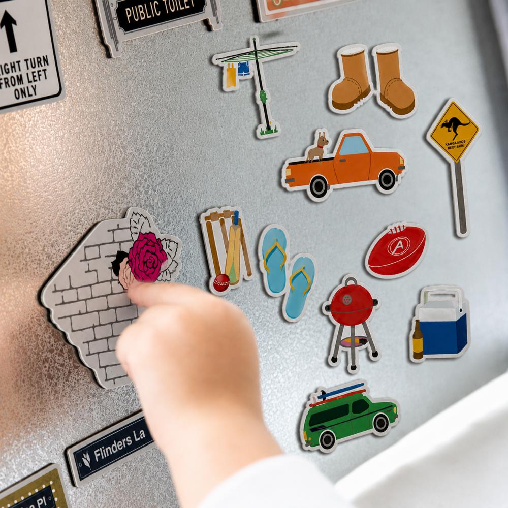Australian icons fridge magnet set featuring a ute, Hills Hoist, thongs, cricket, BBQ, footy, Akubra-style hat, boots, sunscreen and Esky.