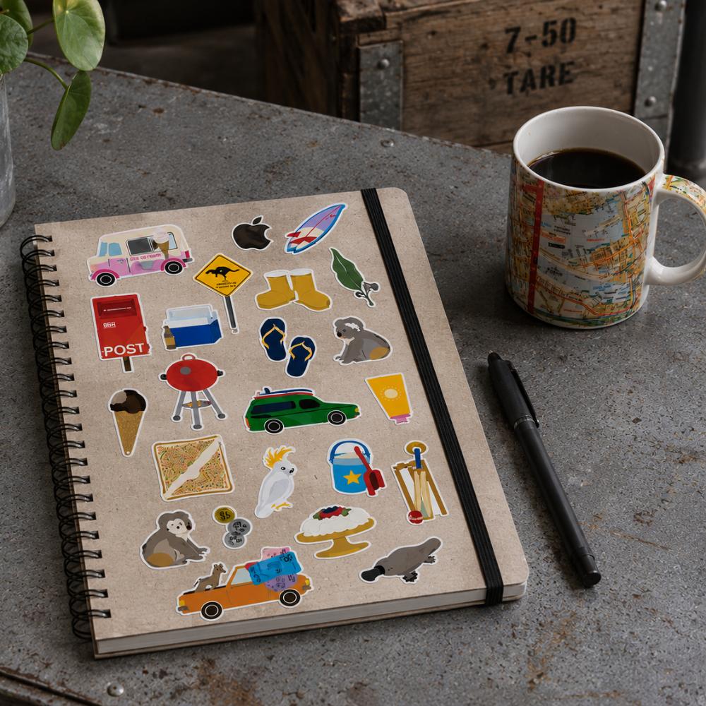 Two-sheet Aussie Icons Sticker Set in clear retail packaging featuring colourful Australian icons including Fairy Bread, kangaroo, koala, ute, BBQ, pavlova, post box, beach gear, ice cream van, cricket, thongs, coins and other nostalgic Australian favourites.