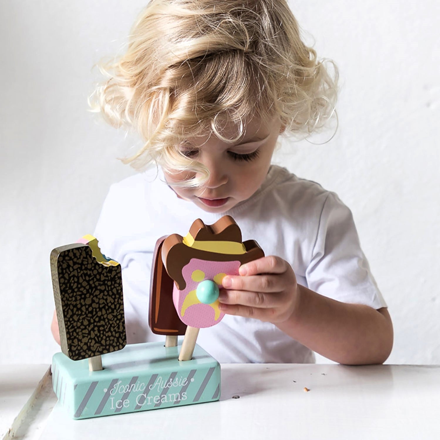 Wooden toy ice cream set with Bubble O’ Bill, Golden Gaytime, Mint Choc Wedge, Rainbow Paddle Pop, wooden stand and paper bags for pretend play.