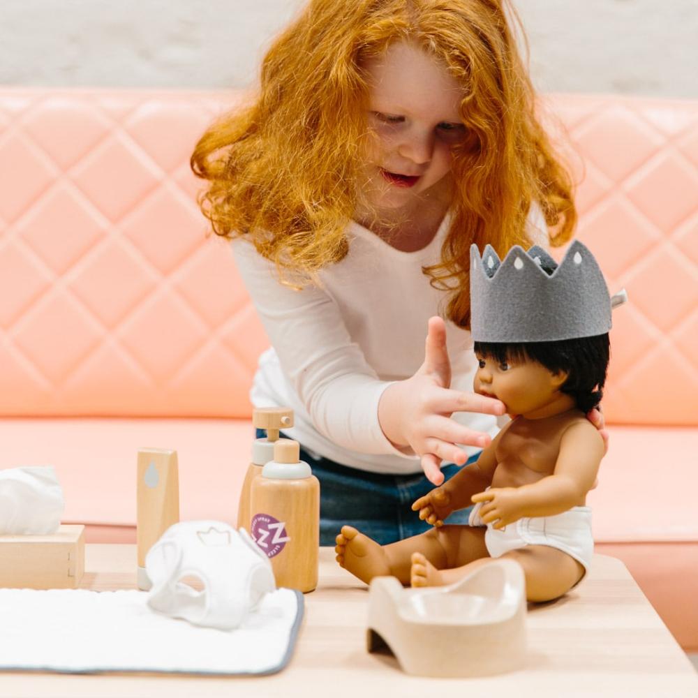Wooden toy Doll Nurturing Kit made of wood and fabric for kids with potty, wipes, nappies, and accessories designed for pretend play, nurturing, and hands-on role-play activities.