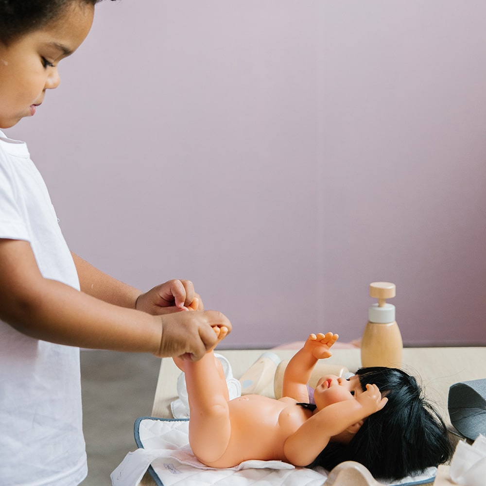 Wooden toy Doll Nurturing Kit made of wood and fabric for kids with potty, wipes, nappies, and accessories designed for pretend play, nurturing, and hands-on role-play activities.