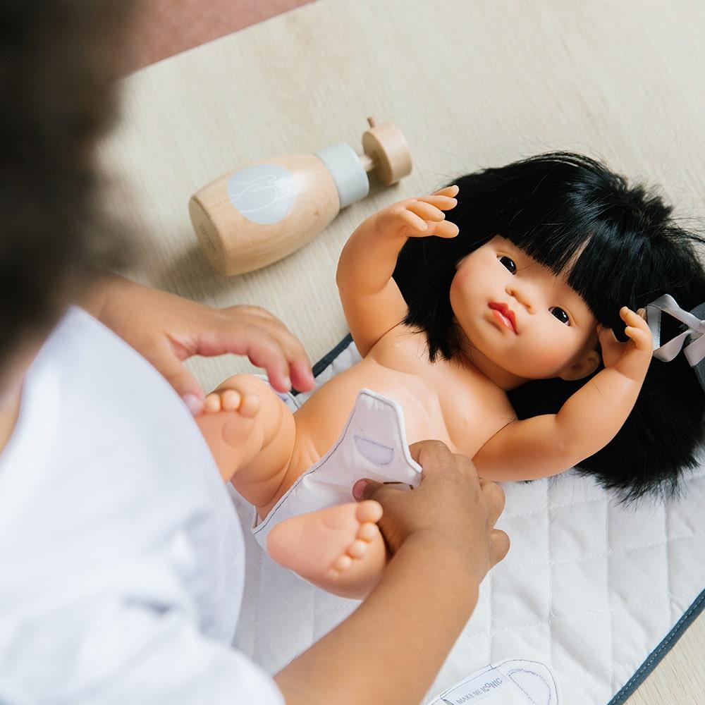 Wooden toy Doll Nurturing Kit made of wood and fabric for kids with potty, wipes, nappies, and accessories designed for pretend play, nurturing, and hands-on role-play activities.