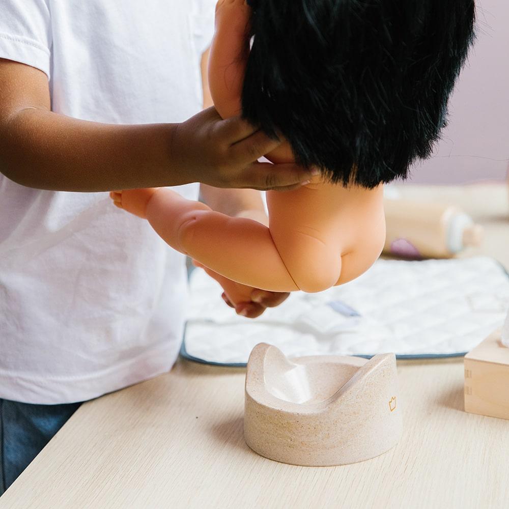 Wooden toy Doll Nurturing Kit made of wood and fabric for kids with potty, wipes, nappies, and accessories designed for pretend play, nurturing, and hands-on role-play activities.