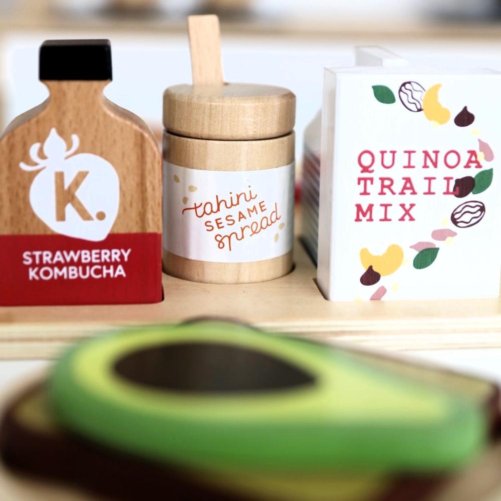 Make Me Iconic wooden Healthy Tummy Brekkie or Breakfast Tray featuring toy avocado toast, kombucha, almond milk, goat's cheese, and tahini spread. A 21-piece wooden breakfast play set inspired by Aussie café culture, perfect for pretend play, creativity, and healthy food learning.
