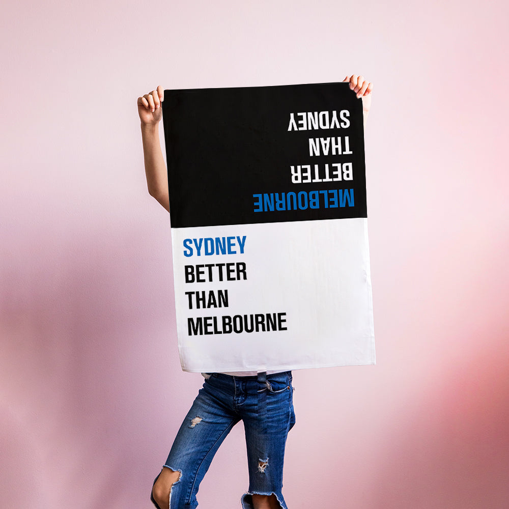 Make Me Iconic Choice Tea Towel with bold double-sided print, Melbourne vs Sydney rivalry in playful, nostalgic kitchen style.