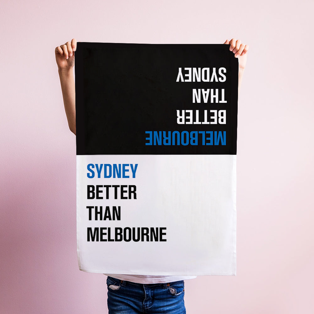 Make Me Iconic Choice Tea Towel with bold double-sided print, Melbourne vs Sydney rivalry in playful, nostalgic kitchen style.