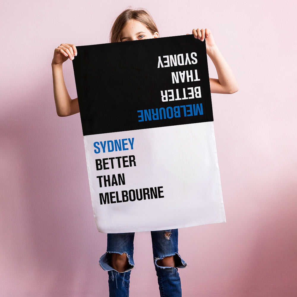 Make Me Iconic Choice Tea Towel with bold double-sided print, Melbourne vs Sydney rivalry in playful, nostalgic kitchen style.