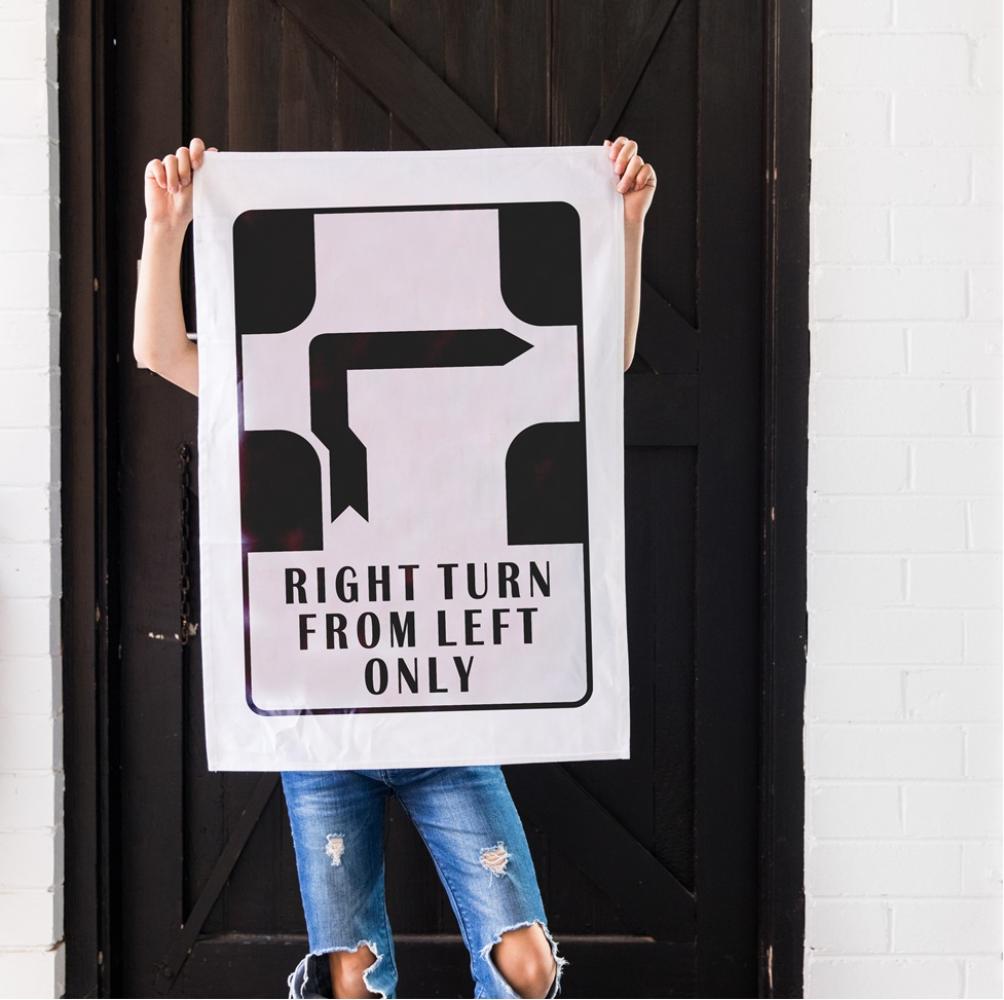 Make Me Iconic’ Melbourne Hook Turn Tea Towel featuring the iconic "Right Turn from Left Only" road sign in bold black and white. A playful nod to Melbourne’s famously confusing driving rule, printed on a cotton-linen blend towel perfect for kitchens, gifts, or nostalgic decor.