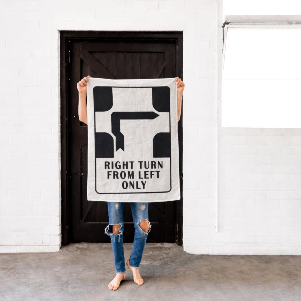 Make Me Iconic’ Melbourne Hook Turn Tea Towel featuring the iconic "Right Turn from Left Only" road sign in bold black and white. A playful nod to Melbourne’s famously confusing driving rule, printed on a cotton-linen blend towel perfect for kitchens, gifts, or nostalgic decor.
