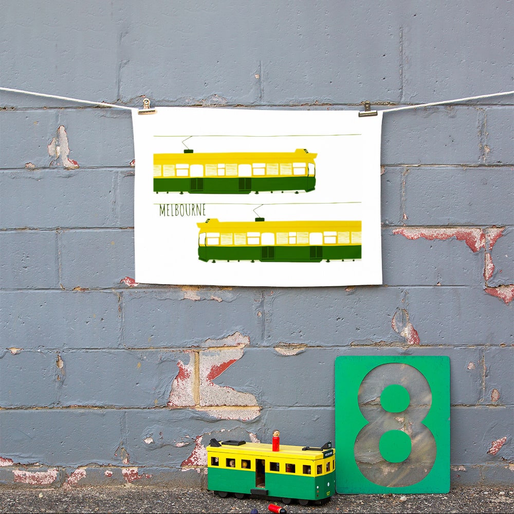 Make Me Iconic Melbourne Tram Tea Towel featuring the classic green and gold W-Class tram with vintage destination banner, an iconic Australian gift and kitchen textile.