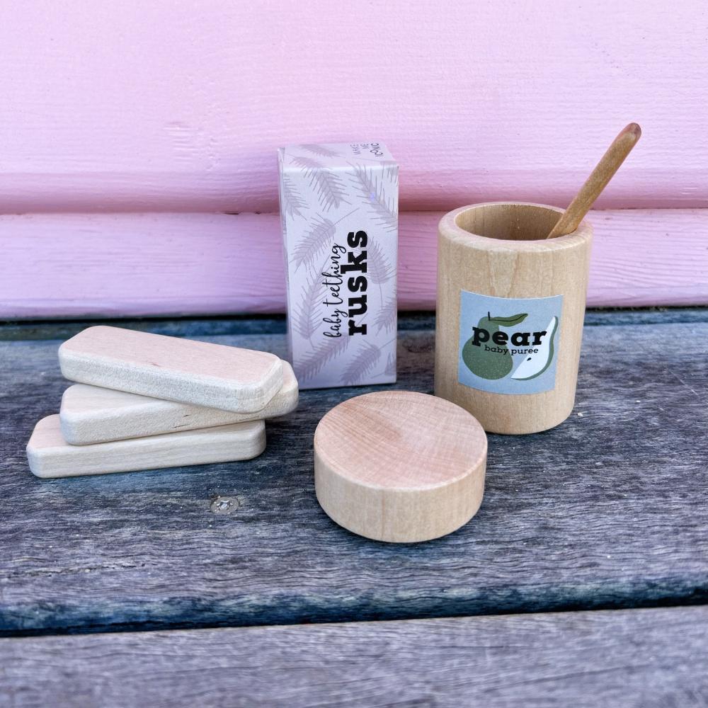 Make Me Iconic set of 3 wooden toy doll rusks in a cardboard box, designed for pretend feeding and nurturing role-play. Perfect for developing empathy, fine motor skills, and imaginative play in young children.