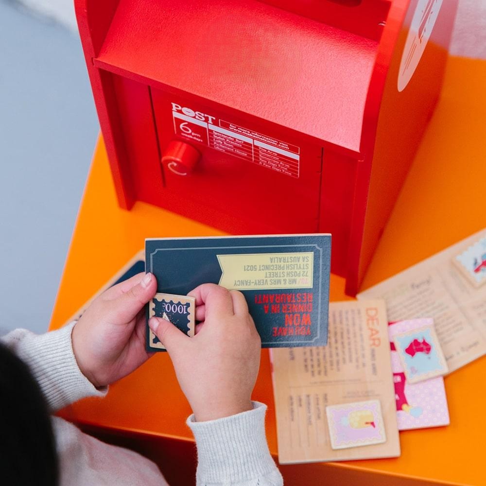 Australian Post Box wooden toy featuring a working mail slot, wooden letters, postcards and stamps. A nostalgic role-play toy inspired by the iconic red Australia Post Box.