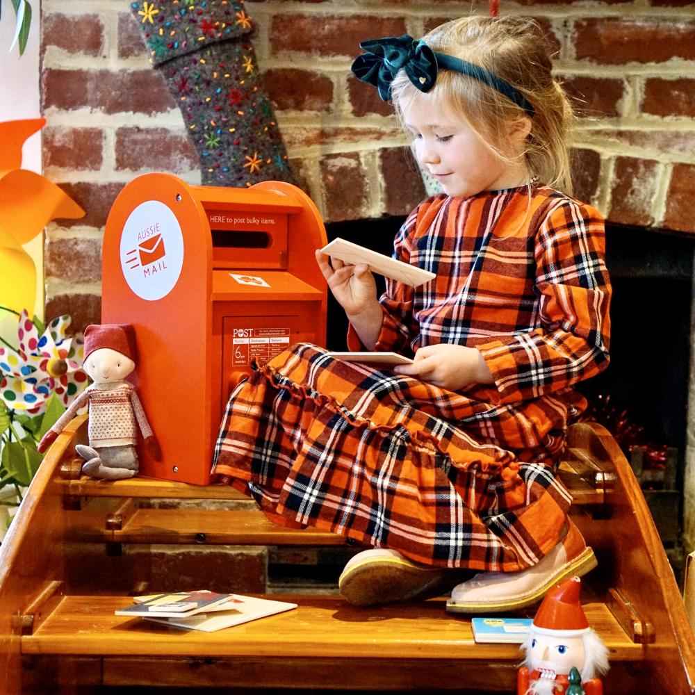 Australian Post Box wooden toy featuring a working mail slot, wooden letters, postcards and stamps. A nostalgic role-play toy inspired by the iconic red Australia Post Box.