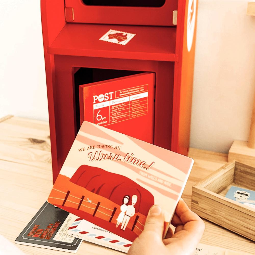 Australian Post Box wooden toy featuring a working mail slot, wooden letters, postcards and stamps. A nostalgic role-play toy inspired by the iconic red Australia Post Box.