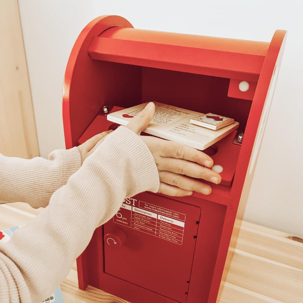 Australian Post Box wooden toy featuring a working mail slot, wooden letters, postcards and stamps. A nostalgic role-play toy inspired by the iconic red Australia Post Box.
